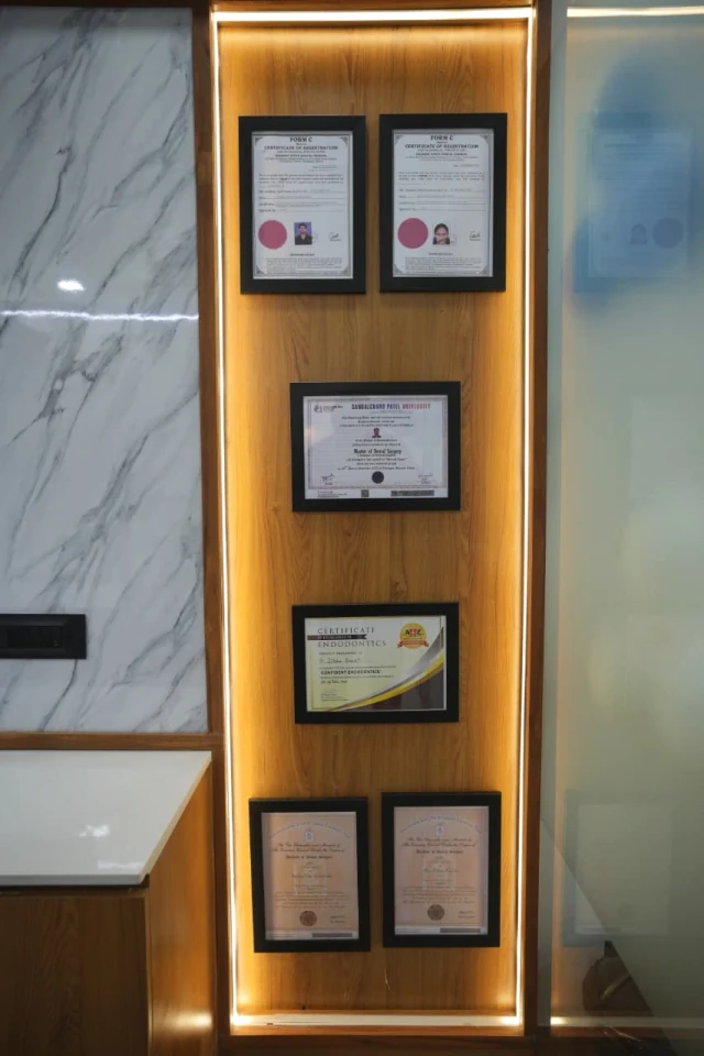 Framed registration and educational certificates displayed on the clinic wall